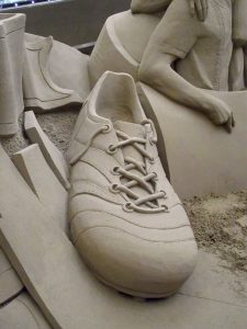 Sand-Replik eines Fußballschuhs